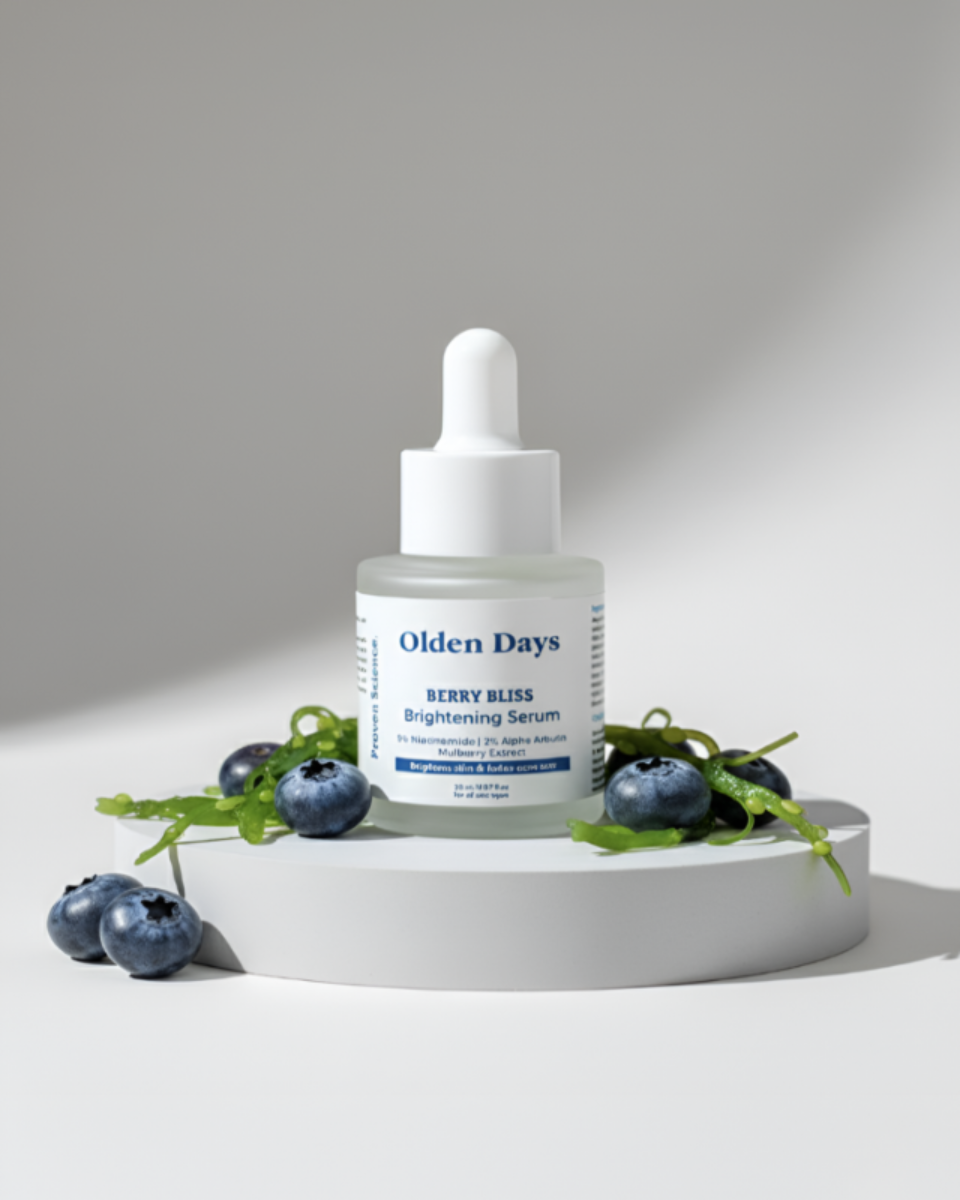 Olden Days Berry Bliss Brightening Serum bottle with blueberries on a gray background